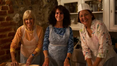 Three travellers posing for a photo together during a pierogi making class.