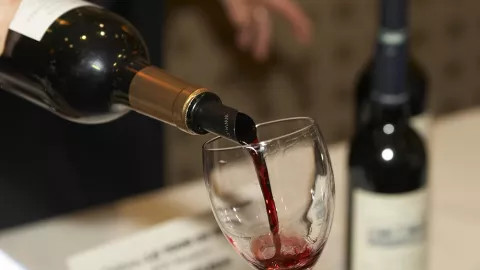 A glass of wine being poured at a wine tasting event