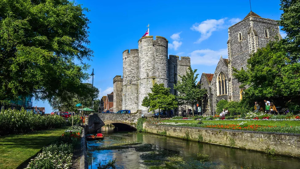 A view of a feudal castle by a canal in the city of Canterbury.