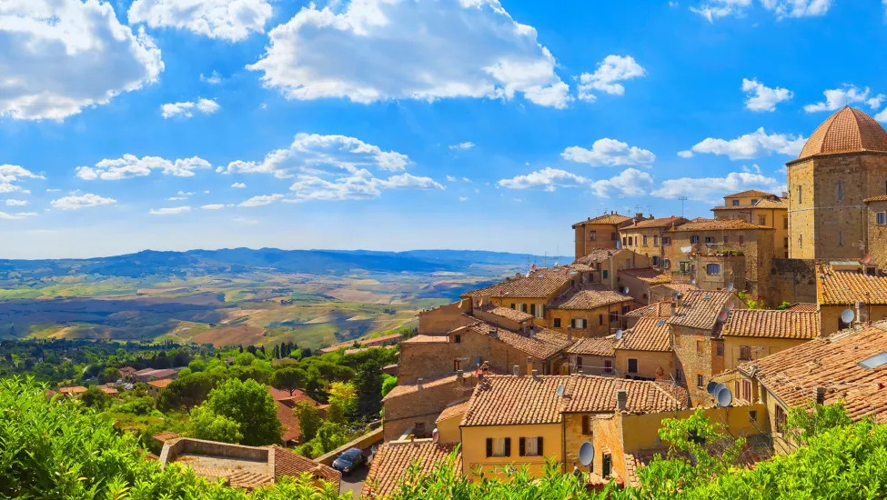 A landscape view of the town of Volterra, with the grand Tuscany countryside in the background.