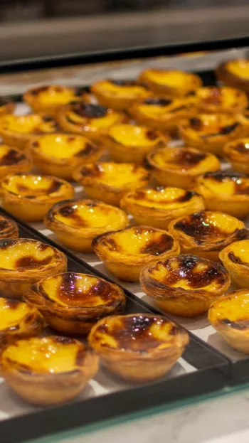 Trays of pastel de nada pastries on display.