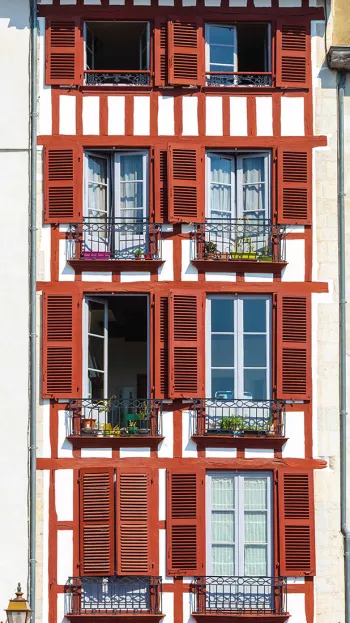 Rows of windows adorn a brightly colored building in Bayonne.