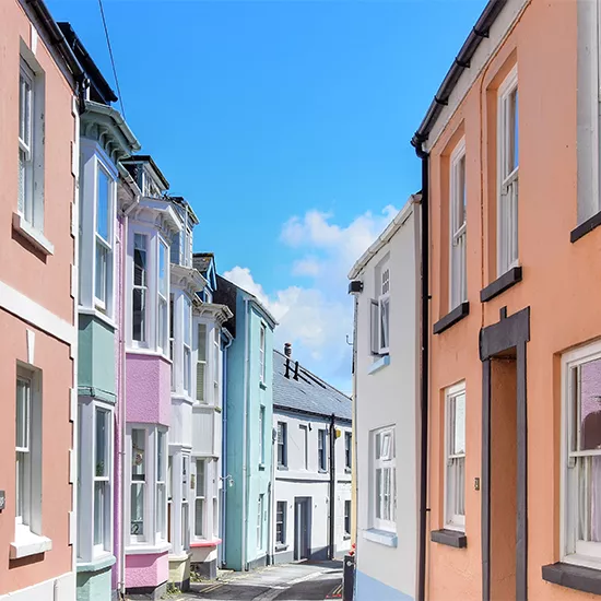 Multi-coloured houses line the streets of a coastal town in Devon.