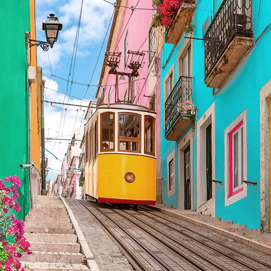 A small tram travels down the steep roads of Lisbon.