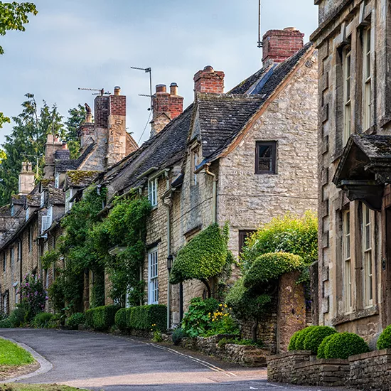 Old houses line the street in a town in the Cotswolds.