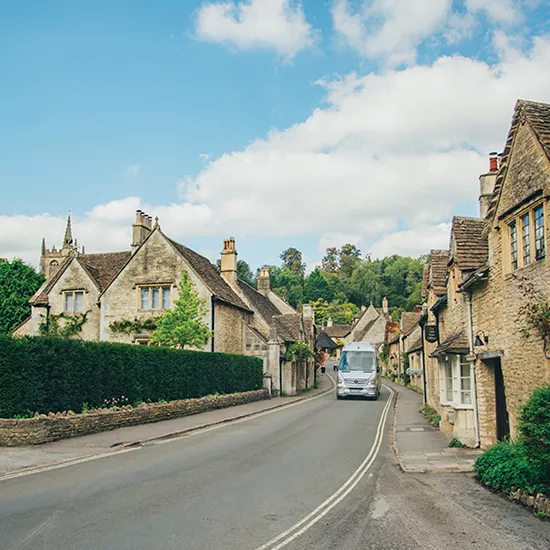 A tour bus drives through the northern English countryside.
