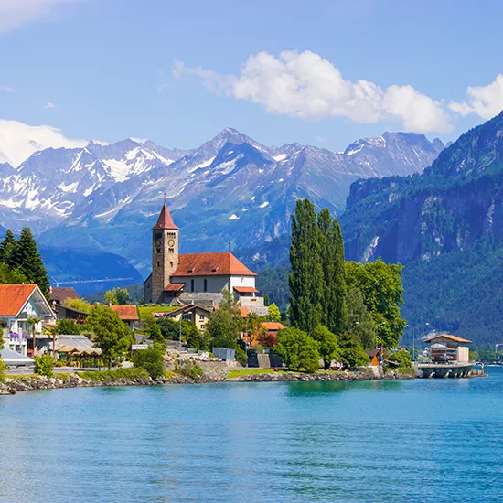 A coastal view of a small Swiss town along the coastline of Lake Brienz.