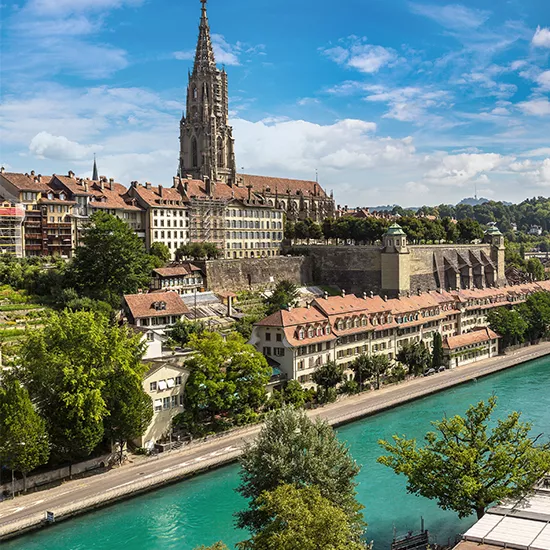 A landscape view of the city of Bern and its canal, with the Cathedral of Bern featuring prominently.
